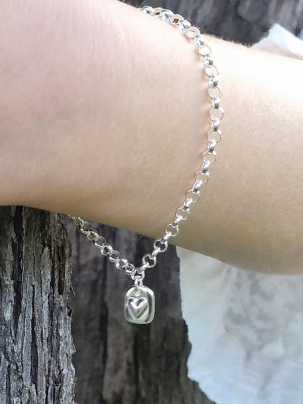 Hjärttag som armband på arm - silversmycke i äkta silver - handgjort silversmycken från Brokig silversmycken